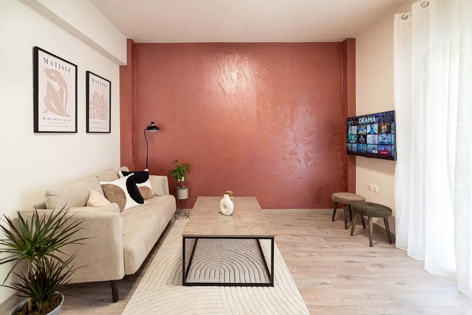 סלון עם קיר ורוד וספה, דירת Airbnb באתונה